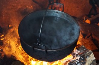 Fotografia przedstawia wnętrze szałasu rodziny Lasaków pochodzącej z Cichego i wypasującej owce na Orawie, na Ziębowej Polanie. We wnętrzu szałasu, po lewej stronie znajduje się palenisko postawione na gołej ziemi, obudowane cegłami i kamieniami. Nad nim zawieszono metalowy kocioł służący do grzania wody, wiszący na łańcuchu.